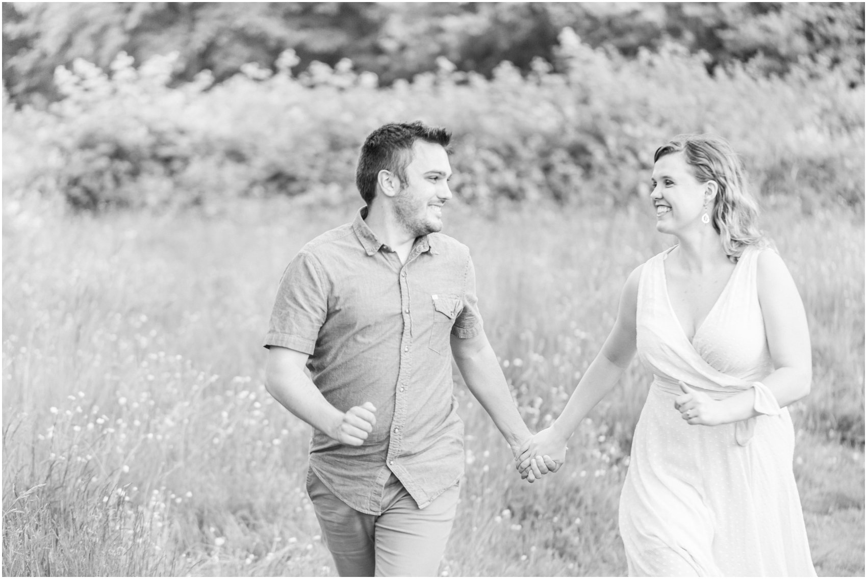 Engaged couple running through the grassy field of Redwood Park Surrey