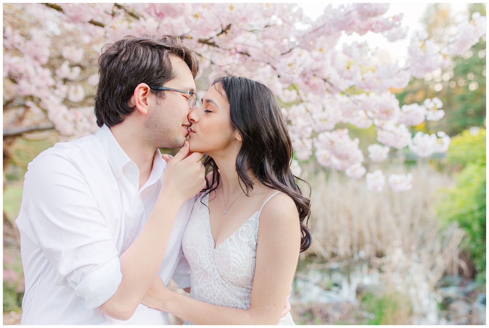Richmond BC Engagement Photos at Minoru Park, couple kissing with backdrop of Cherry Blossoms