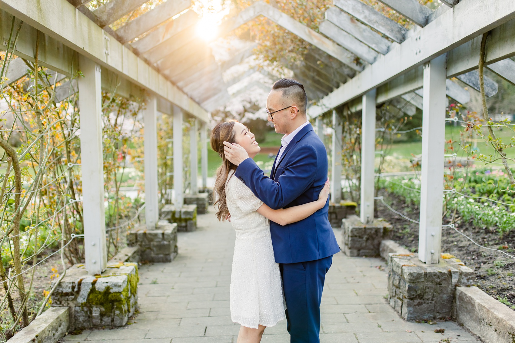 Engagement photo taken at Stanley Park Rose Garden, backlit by golden light from the sun 
