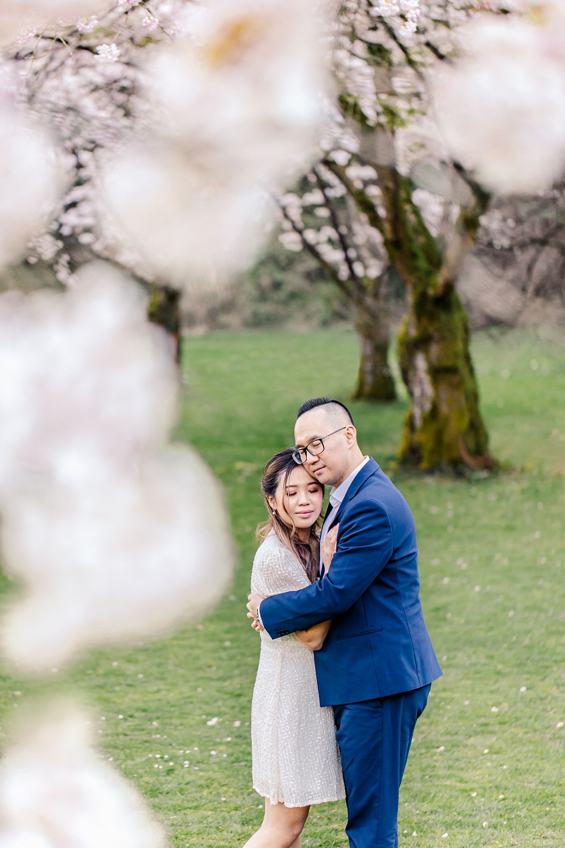 Stanley Park Cherry Blossoms engagement photo in Vancouver, BC, bride and groom embracing under the cherry blossoms